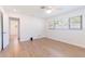 Bright bedroom features wood-look flooring, ceiling fan, and a view into the other room at 2019 Inner S Cir, St Petersburg, FL 33712