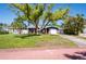 Desirable home featuring a green lawn, mature trees, and a driveway leading to an attached garage at 2019 Inner S Cir, St Petersburg, FL 33712
