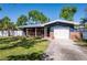 Inviting home exterior showcasing a well-maintained lawn, shade trees, and a cozy front porch with brick accents at 2019 Inner S Cir, St Petersburg, FL 33712
