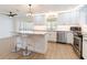 Open kitchen featuring white cabinets, stainless appliances, stone countertops, and center island with seating at 2019 Inner S Cir, St Petersburg, FL 33712
