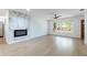 Bright living room with modern fireplace, tile floors, ceiling fan, and views of the front yard at 2019 Inner S Cir, St Petersburg, FL 33712