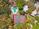 Aerial view featuring tennis courts and pool, surrounded by lush greenery and community buildings at 2644 2Nd Ct, Palm Harbor, FL 34684