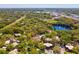 Scenic aerial view of the community with lush greenery, tennis court, lake and beautiful landscape at 2644 2Nd Ct, Palm Harbor, FL 34684