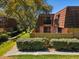 Home exterior with a tiled roof, balconies, and surrounded by mature trees and greenery at 2644 2Nd Ct, Palm Harbor, FL 34684