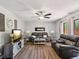 Comfortable living room with a modern fireplace, ceiling fan, and stylish furnishings at 2644 2Nd Ct, Palm Harbor, FL 34684