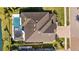 An aerial view showcases the home's roof, private pool, covered outdoor seating area, and landscaping at 28355 Picana, Wesley Chapel, FL 33543