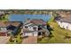 Stunning aerial view of a two-story home with manicured lawn, three-car garage and a tranquil lake in the back at 28355 Picana, Wesley Chapel, FL 33543