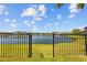 Serene backyard view of a tranquil lake with a fence, promising both privacy and picturesque scenery at 28355 Picana, Wesley Chapel, FL 33543