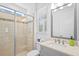 Bright bathroom featuring a glass-enclosed shower, vanity with sink, and window providing natural light at 28355 Picana, Wesley Chapel, FL 33543