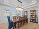 Dining room with a modern chandelier, dining table, and glass display cabinet at 28355 Picana, Wesley Chapel, FL 33543