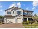 Beautiful two-story home featuring a three-car garage, manicured lawn, and a paver driveway at 28355 Picana, Wesley Chapel, FL 33543