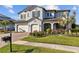 Beautiful two-story home featuring a three-car garage, manicured lawn, and a paver driveway at 28355 Picana, Wesley Chapel, FL 33543