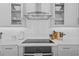 Kitchen area includes a stainless hood vent, tile backsplash, oven, and white countertops at 28355 Picana, Wesley Chapel, FL 33543