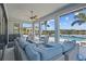 Spacious covered patio features a comfortable seating area, ceiling fan, and views of the pool and lake at 28355 Picana, Wesley Chapel, FL 33543