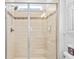 Modern shower featuring a tiled surround, glass doors, shower head, and a window for natural light at 28355 Picana, Wesley Chapel, FL 33543