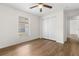 Well-lit bedroom with ceiling fan, closet, and wood-look laminate flooring at 29250 Princeville Dr, San Antonio, FL 33576