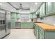 Well-lit kitchen featuring stainless steel appliances, light-green cabinets, and light butcher block countertops at 320 Lake Maggiore S Blvd, St Petersburg, FL 33705