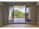View from the interior to a balcony with sliding glass doors and views of green trees at 3210 Mangrove Point Dr, Ruskin, FL 33570