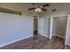 Bedroom featuring a ceiling fan, wood floors, a walk-in closet, and a white door at 3210 Mangrove Point Dr, Ruskin, FL 33570