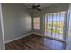 This bedroom features wood floors, a ceiling fan, a sliding door to a balcony, and a view at 3210 Mangrove Point Dr, Ruskin, FL 33570