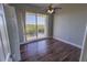 Bright bedroom with ceiling fan, wood floors, and sliding doors to a balcony with water view at 3210 Mangrove Point Dr, Ruskin, FL 33570