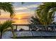 Scenic sunset view overlooking the ocean with a wooden boardwalk and lush palm trees at 3210 Mangrove Point Dr, Ruskin, FL 33570