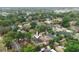 An aerial view shows the property nestled in a leafy neighborhood surrounded by mature trees and other homes at 3422 E Powhatan Ave, Tampa, FL 33610