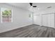 Bright bedroom featuring wood-look flooring, neutral walls, and closet space at 3422 E Powhatan Ave, Tampa, FL 33610