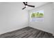 The clean bedroom has hardwood floors, a ceiling fan and a large window overlooking the outdoors at 3422 E Powhatan Ave, Tampa, FL 33610