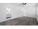 Spacious bedroom showcasing wood-look floors, a ceiling fan, and bright, white walls at 3422 E Powhatan Ave, Tampa, FL 33610