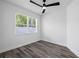 Cozy bedroom featuring wood-look flooring, neutral walls, and a bright window at 3422 E Powhatan Ave, Tampa, FL 33610