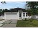 Charming single-Gathering home with white exterior, well-maintained landscaping, and a two-car garage at 3422 E Powhatan Ave, Tampa, FL 33610