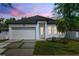 Charming single-story home boasts a well-manicured lawn, white exterior, and attached garage at 3422 E Powhatan Ave, Tampa, FL 33610