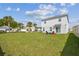 Expansive backyard featuring a well-manicured lawn and colorful Adirondack chairs, perfect for outdoor relaxation and entertainment at 35168 Arya Way, Zephyrhills, FL 33541