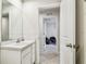 Powder room featuring a large mirror, marble countertop sink, and a decorative open doorway at 35168 Arya Way, Zephyrhills, FL 33541