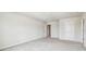 Bright bedroom with light-colored walls, carpeted floors, and multiple access doors at 35168 Arya Way, Zephyrhills, FL 33541