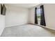Bedroom with a window, dark curtains, and a mounted television on the wall at 35168 Arya Way, Zephyrhills, FL 33541