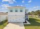 Two-story home with light blue shutters and a two car garage, complemented by a well-manicured lawn at 35168 Arya Way, Zephyrhills, FL 33541