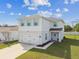 Charming two-story home boasts a two-car garage and lovely light blue shutters, set in a well-maintained lawn at 35168 Arya Way, Zephyrhills, FL 33541