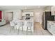 Modern kitchen featuring white cabinets, stainless steel appliances and an island with bar seating at 35168 Arya Way, Zephyrhills, FL 33541