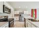 Modern kitchen featuring stainless steel appliances, white cabinetry, and a kitchen island with sink at 35168 Arya Way, Zephyrhills, FL 33541