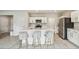 Modern kitchen featuring white cabinets, stainless steel appliances and an island with bar seating at 35168 Arya Way, Zephyrhills, FL 33541