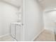 Functional laundry area with modern washer and dryer units adjacent to a hallway at 35168 Arya Way, Zephyrhills, FL 33541