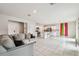 Open living space features tile floors, a kitchen island with barstool seating, and bright, colorful curtains at 35168 Arya Way, Zephyrhills, FL 33541