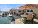 Outdoor patio with a pool, seating area, and waterfront view offers an inviting space for relaxation and entertaining at 4544 Harbor Hills Dr, Largo, FL 33770