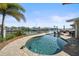 Waterfront pool with chairs in the water, lush greenery, and boat docks at 4544 Harbor Hills Dr, Largo, FL 33770
