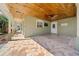 Tiled porch with wood ceiling, ceiling fan, and view to green yard at 4615 Keene Rd, Plant City, FL 33565