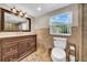 Bathroom featuring a vanity with drawers, window and earth-toned tile at 4615 Keene Rd, Plant City, FL 33565