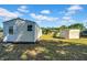 Small outbuildings sit in the grass in this verdant rural backyard at 4615 Keene Rd, Plant City, FL 33565