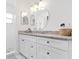 Bright bathroom with granite countertops, large round mirror, and modern fixtures at 4859 Napoli Ne Ct # 4859, St Petersburg, FL 33703